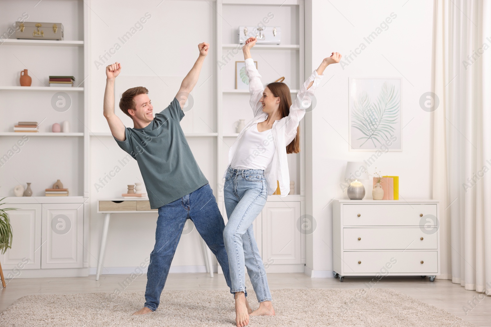 Photo of Happy young couple dancing together at home