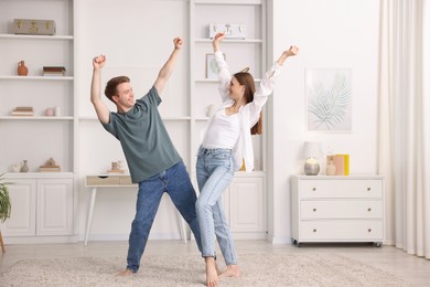 Photo of Happy young couple dancing together at home
