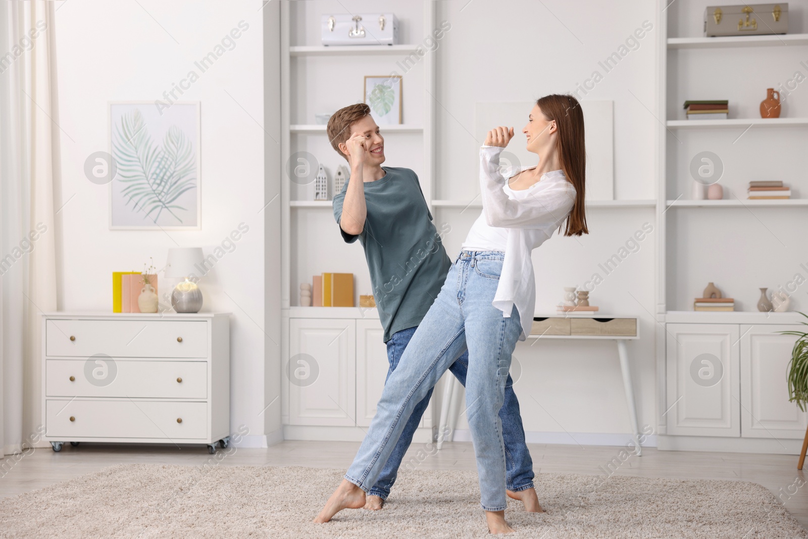 Photo of Happy young couple dancing together at home