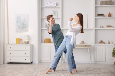 Photo of Happy young couple dancing together at home