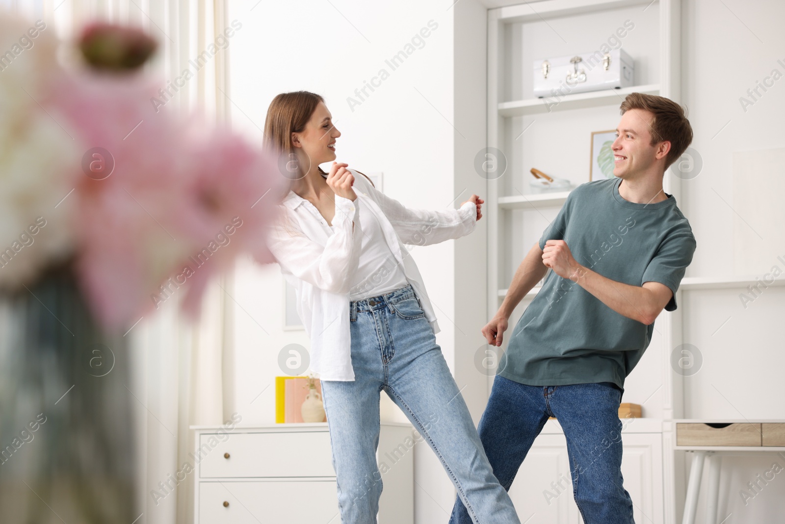 Photo of Happy young couple dancing together at home