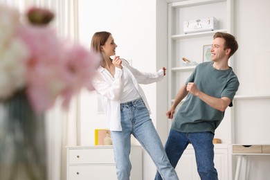 Photo of Happy young couple dancing together at home
