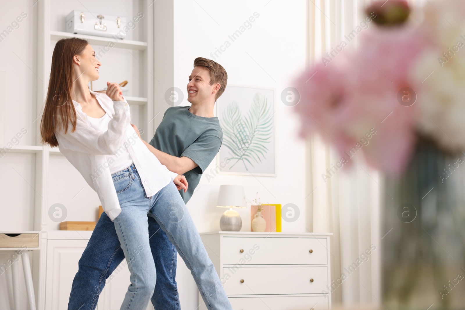 Photo of Happy young couple dancing together at home