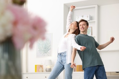 Photo of Happy young couple dancing together at home