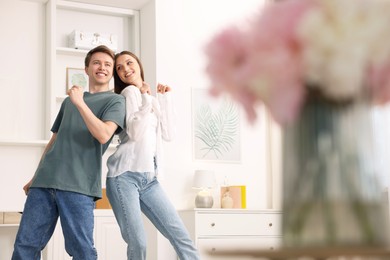 Photo of Happy young couple dancing together at home