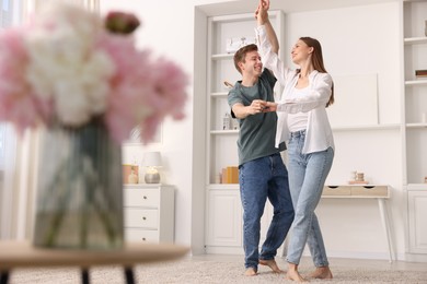 Photo of Happy young couple dancing together at home, low angle view