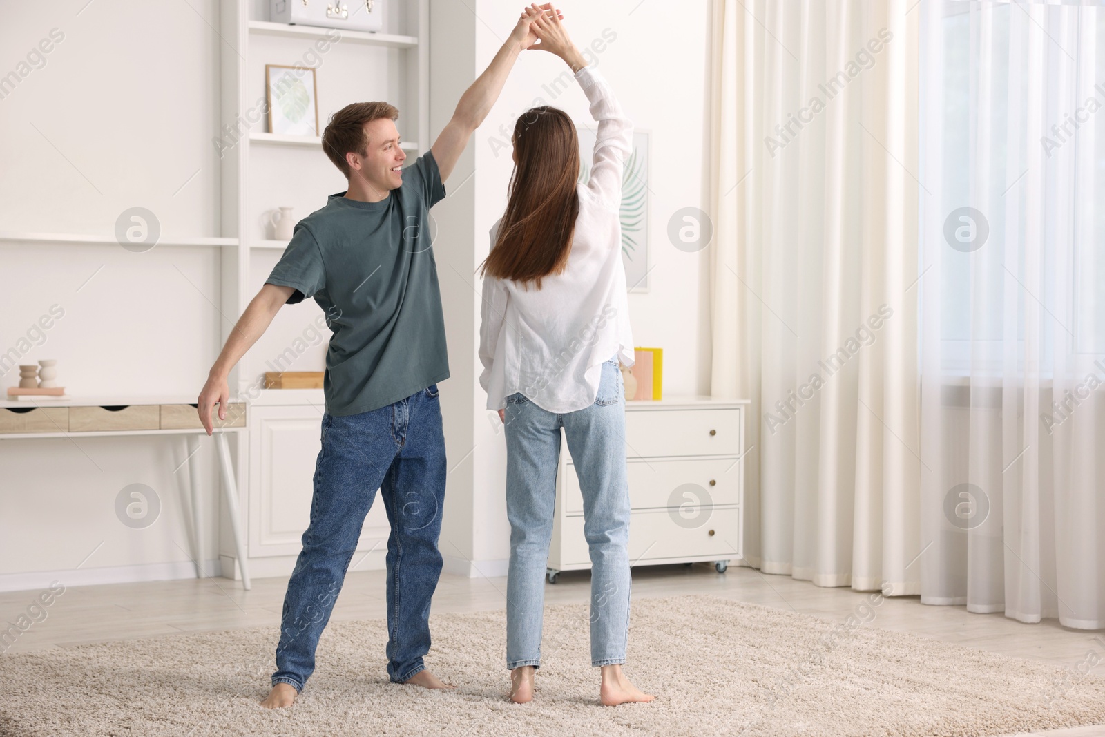 Photo of Happy young couple dancing together at home