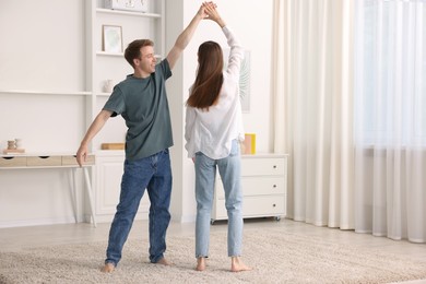 Photo of Happy young couple dancing together at home