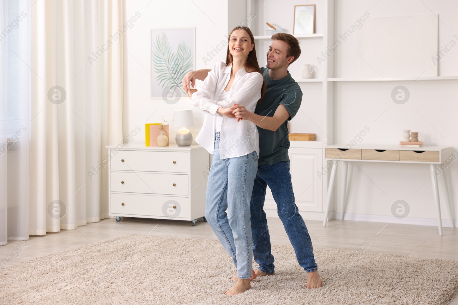 Photo of Happy young couple dancing together at home