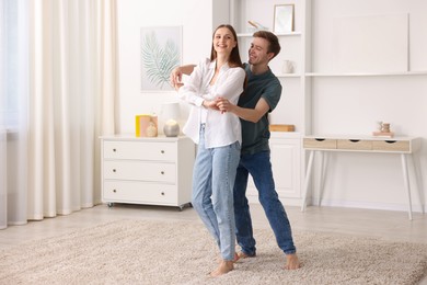 Photo of Happy young couple dancing together at home