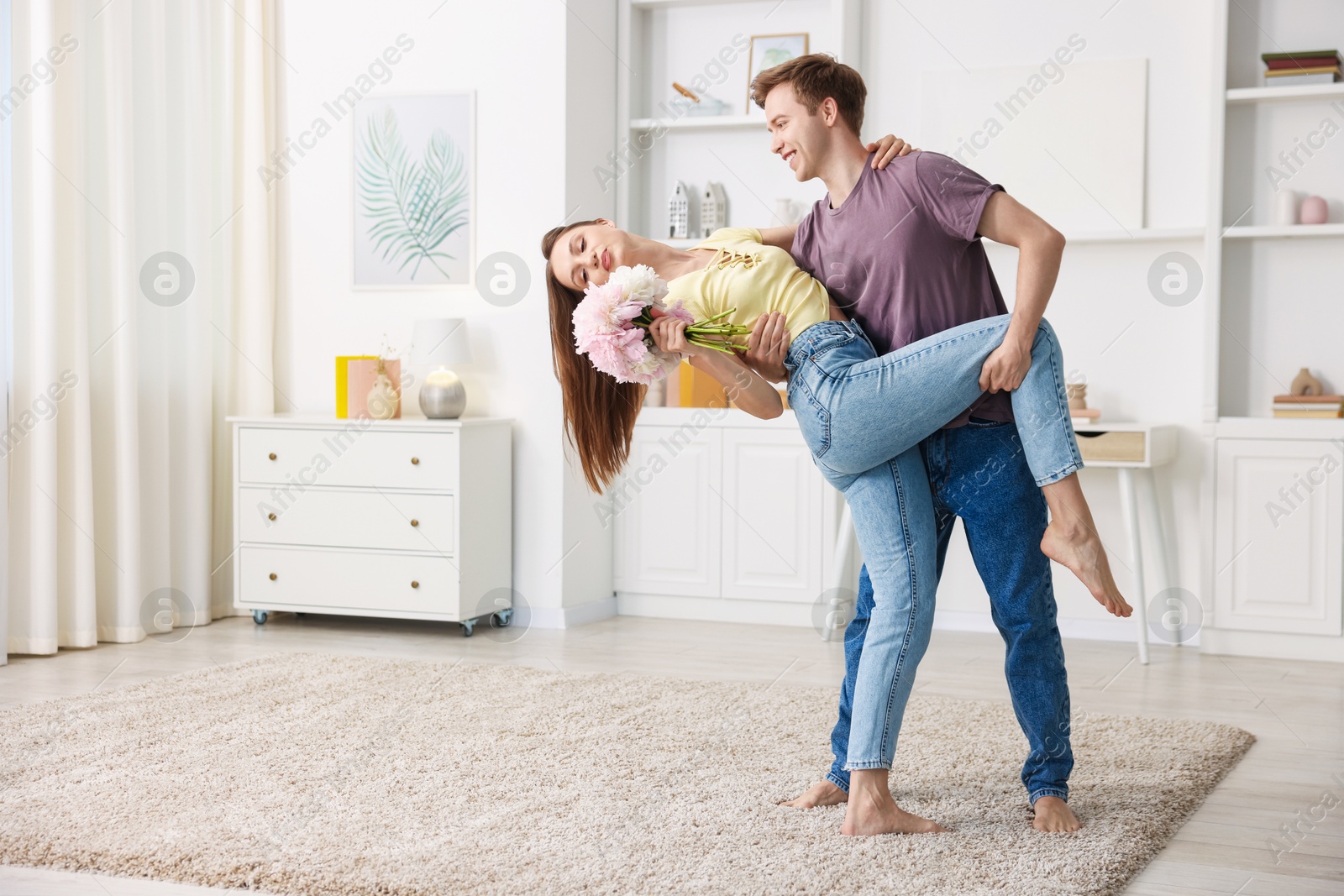 Happy young couple dancing together at home. Space for text Photo of Happy young couple dancing together at home. Space for text