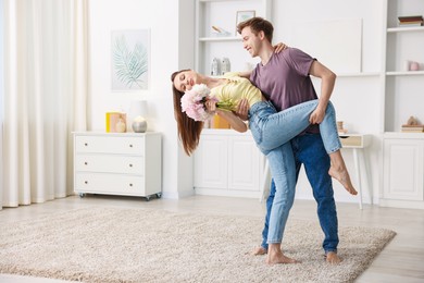 Photo of Happy young couple dancing together at home. Space for text
