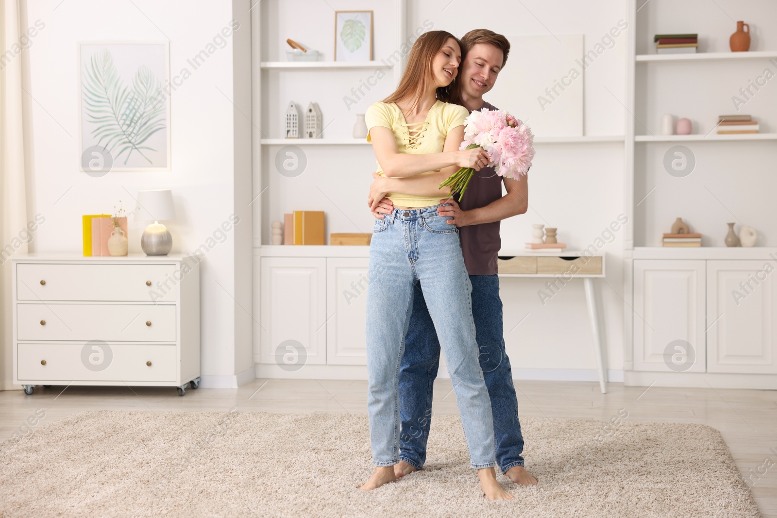 Photo of Happy young couple dancing together at home. Space for text