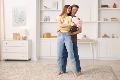 Photo of Happy young couple dancing together at home. Space for text