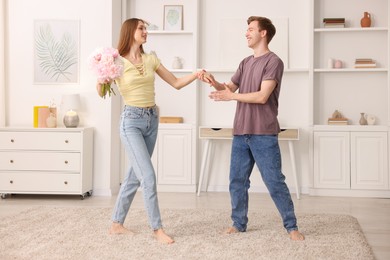 Photo of Happy young couple dancing together at home