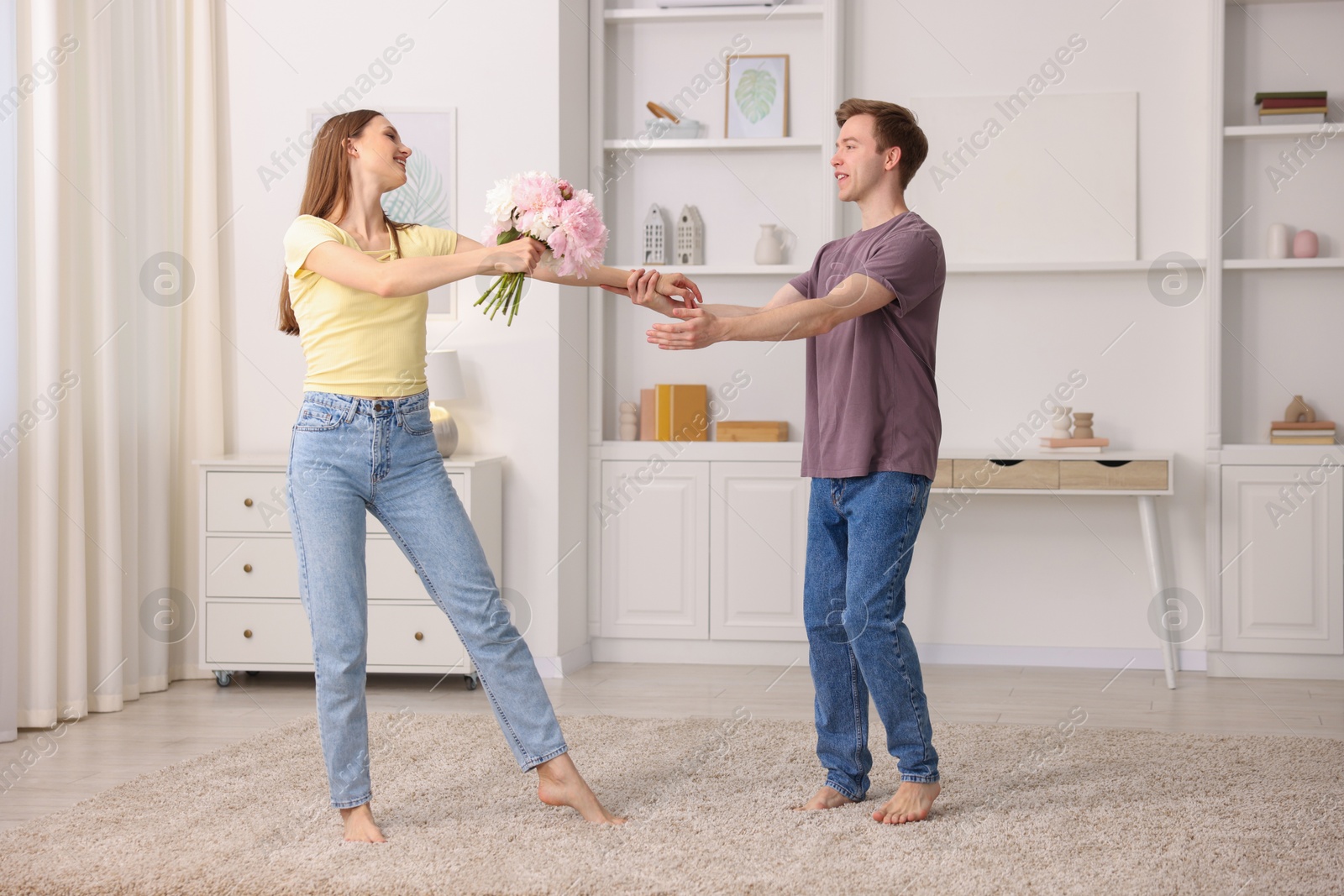 Photo of Happy young couple dancing together at home