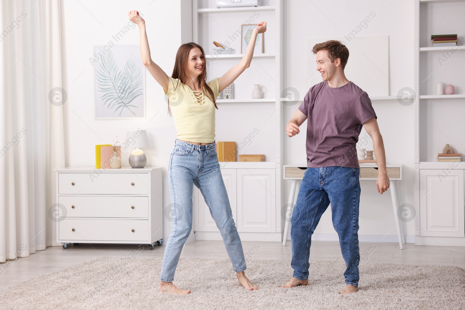 Photo of Happy young couple dancing together at home