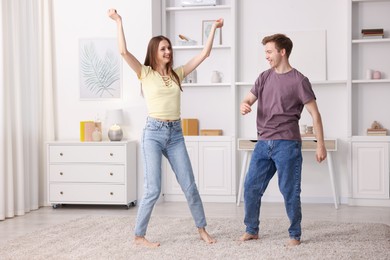 Photo of Happy young couple dancing together at home