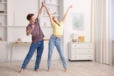 Photo of Happy young couple dancing together at home