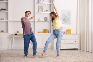 Photo of Happy young couple dancing together at home