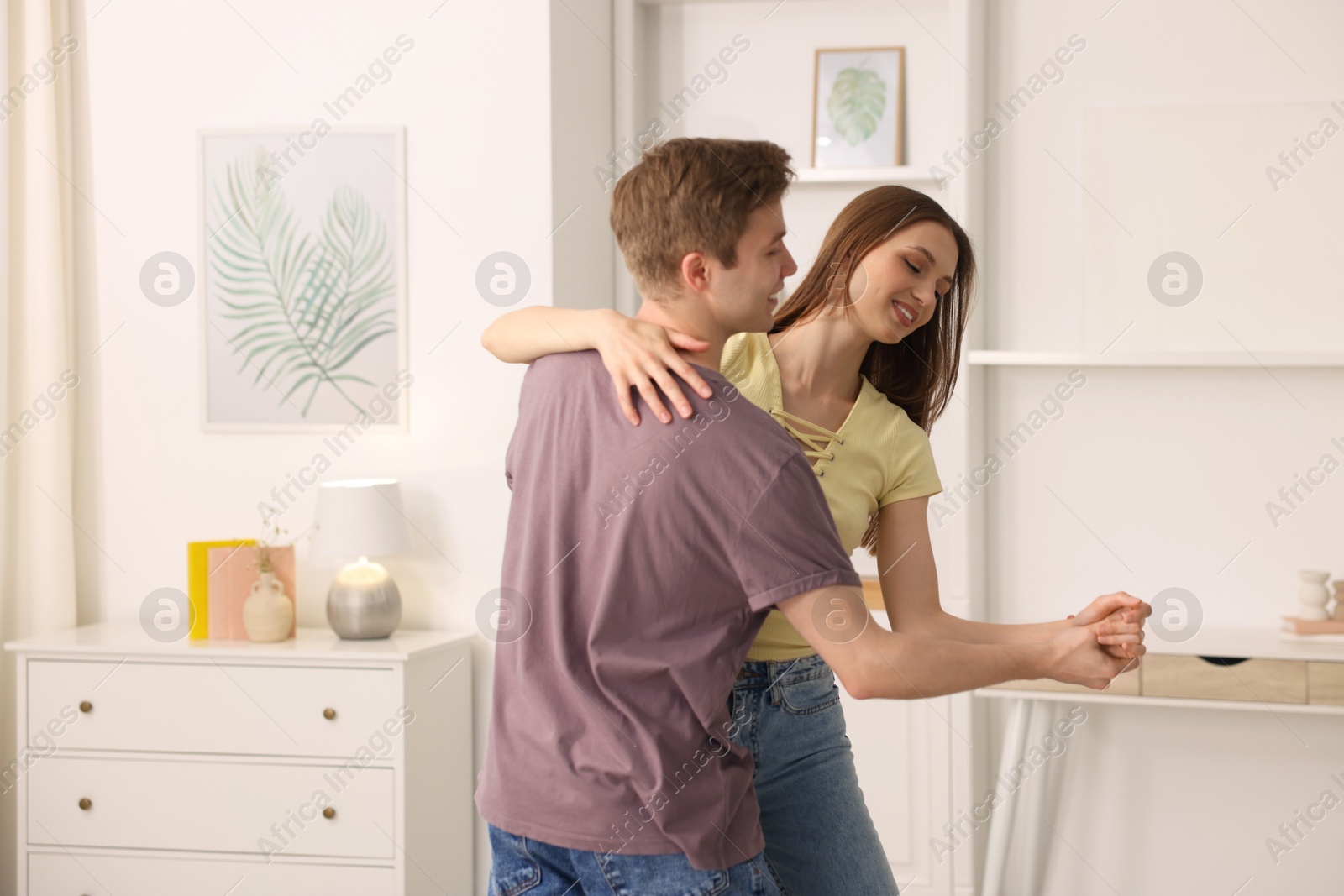 Photo of Happy young couple dancing together at home
