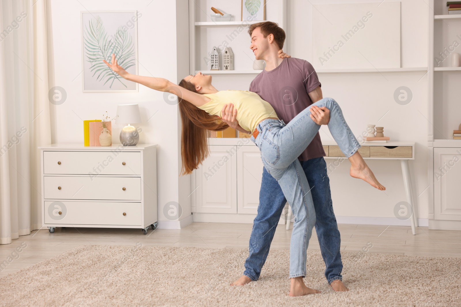 Photo of Happy young couple dancing together at home