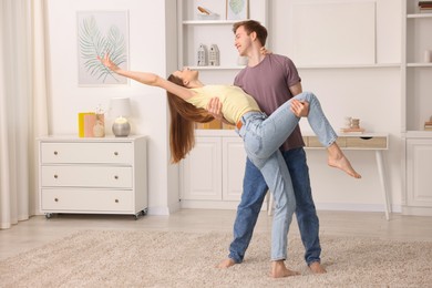 Photo of Happy young couple dancing together at home