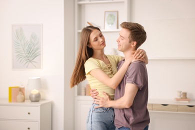Photo of Happy young couple dancing together at home