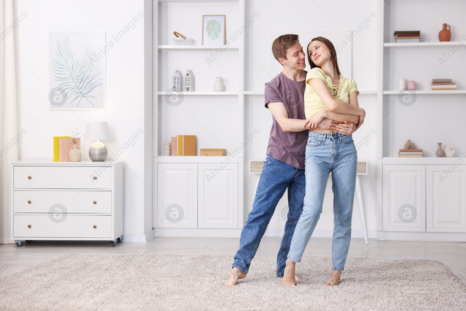 Photo of Happy young couple dancing together at home. Space for text