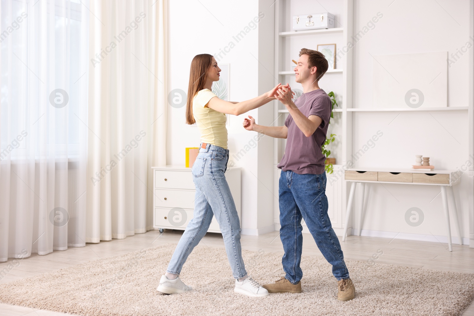 Photo of Happy young couple dancing together at home