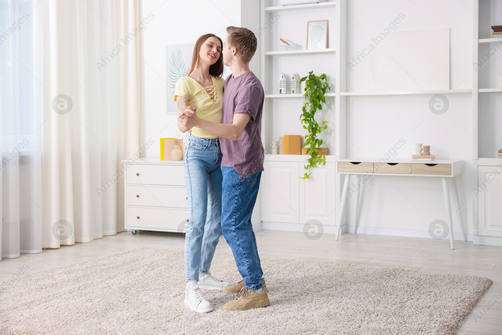 Photo of Happy young couple dancing together at home