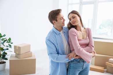 Photo of Young couple dancing and cardboard boxes at home. Moving day