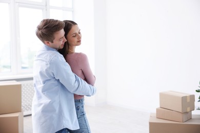 Photo of Young couple dancing and cardboard boxes at home. Moving day