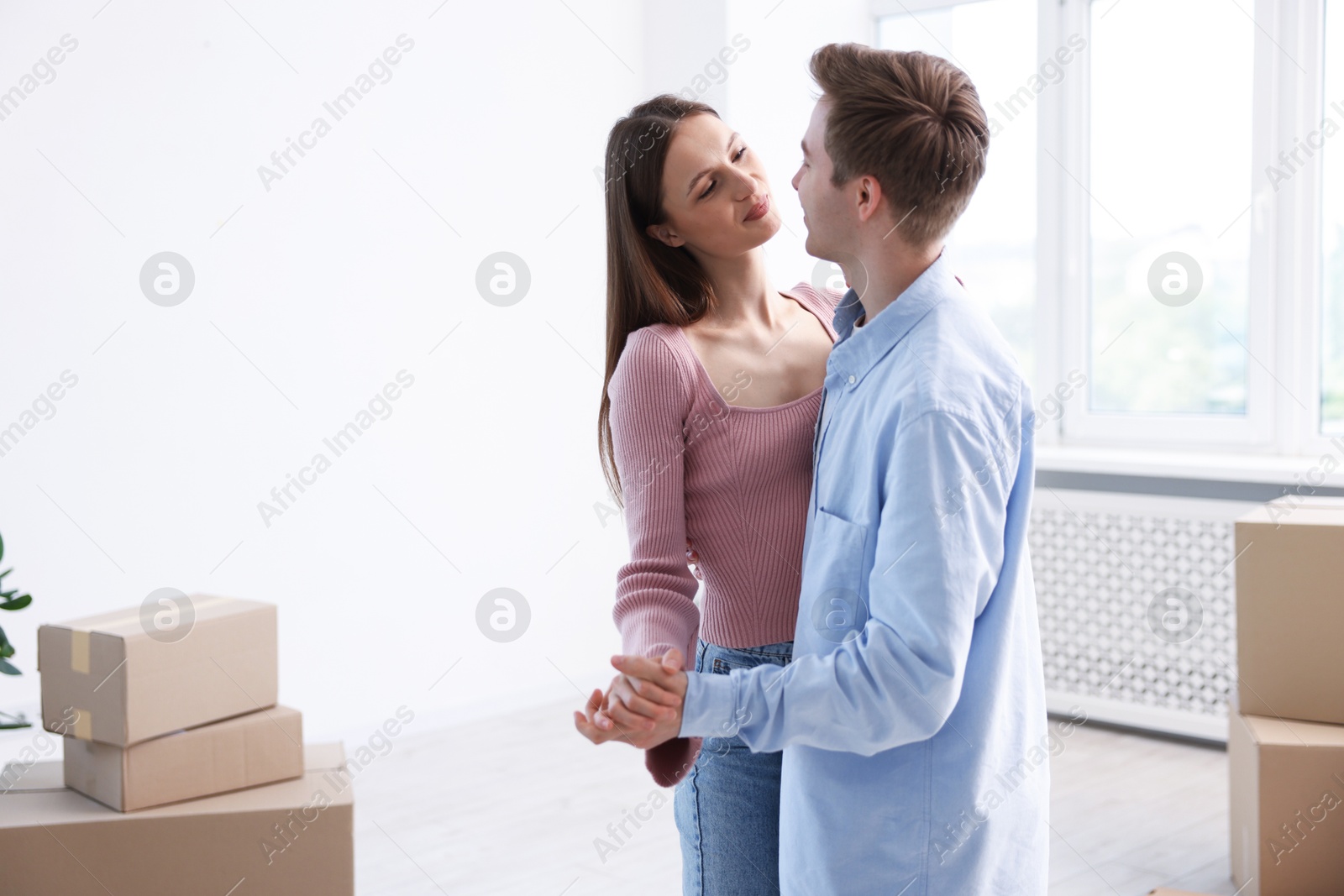Young couple dancing and cardboard boxes at home. Moving day Photo of Young couple dancing and cardboard boxes at home. Moving day