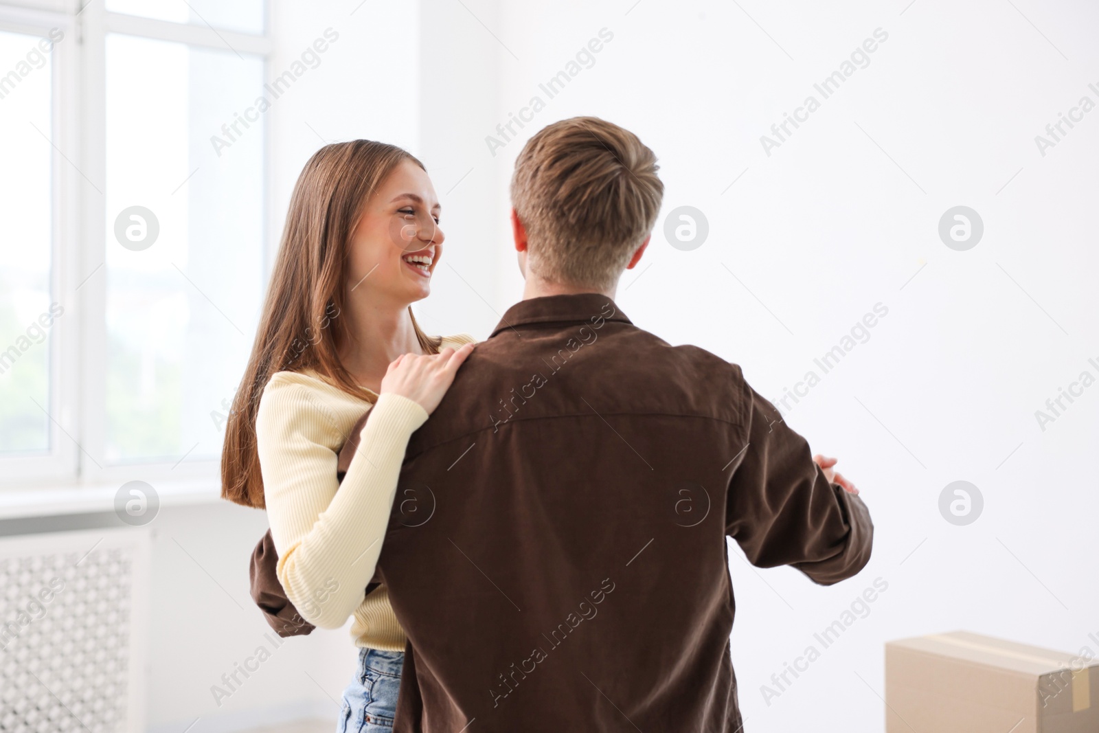 Happy young couple dancing and cardboard box at home. Moving day Photo of Happy young couple dancing and cardboard box at home. Moving day