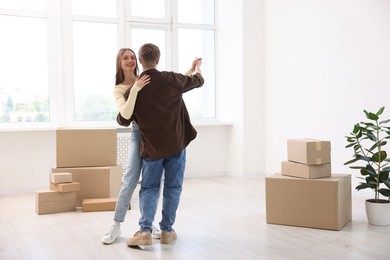 Photo of Happy young couple dancing among moving boxes at home