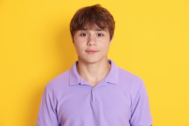 Photo of Portrait of cute teenage boy on yellow background
