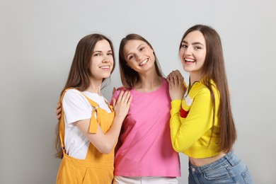 Photo of Friends hugging each other on light grey background