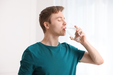 Photo of Man drinking water from glass at home