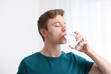 Photo of Man drinking water from glass at home