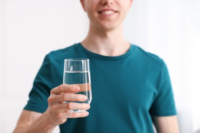 Photo of Man with glass of water at home, selective focus