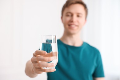 Photo of Man with glass of water at home, selective focus
