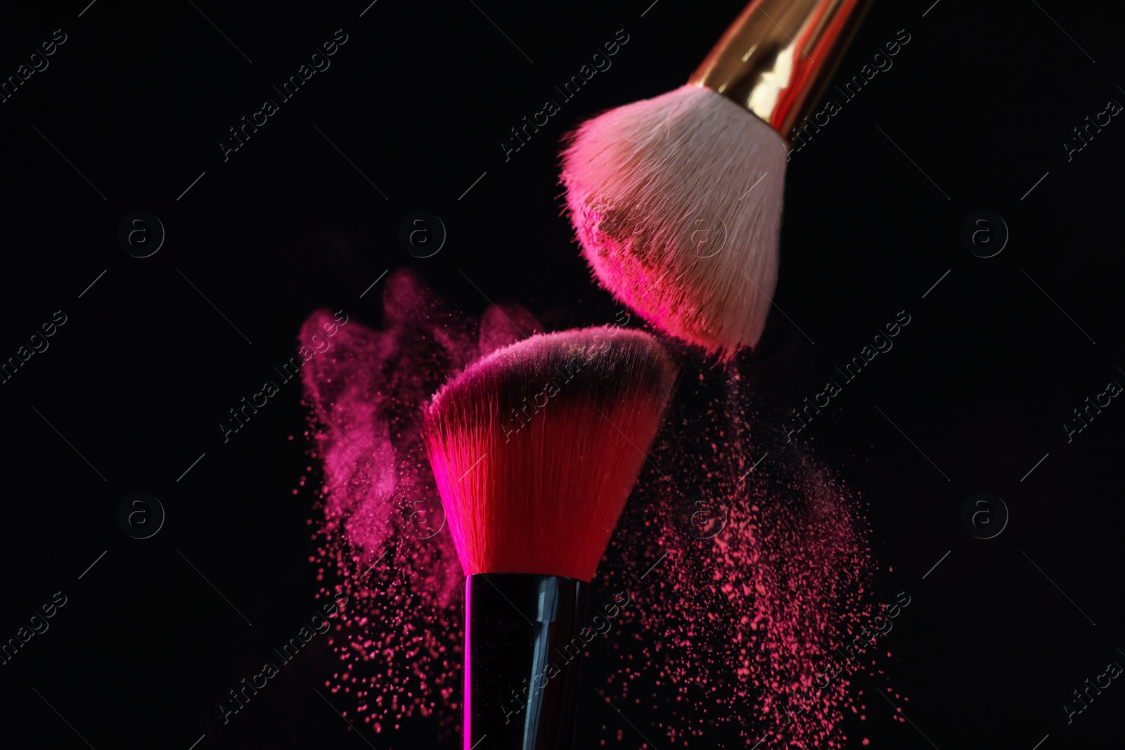 Makeup brushes with pink eye shadow on black background, closeup Photo of Makeup brushes with pink eye shadow on black background, closeup