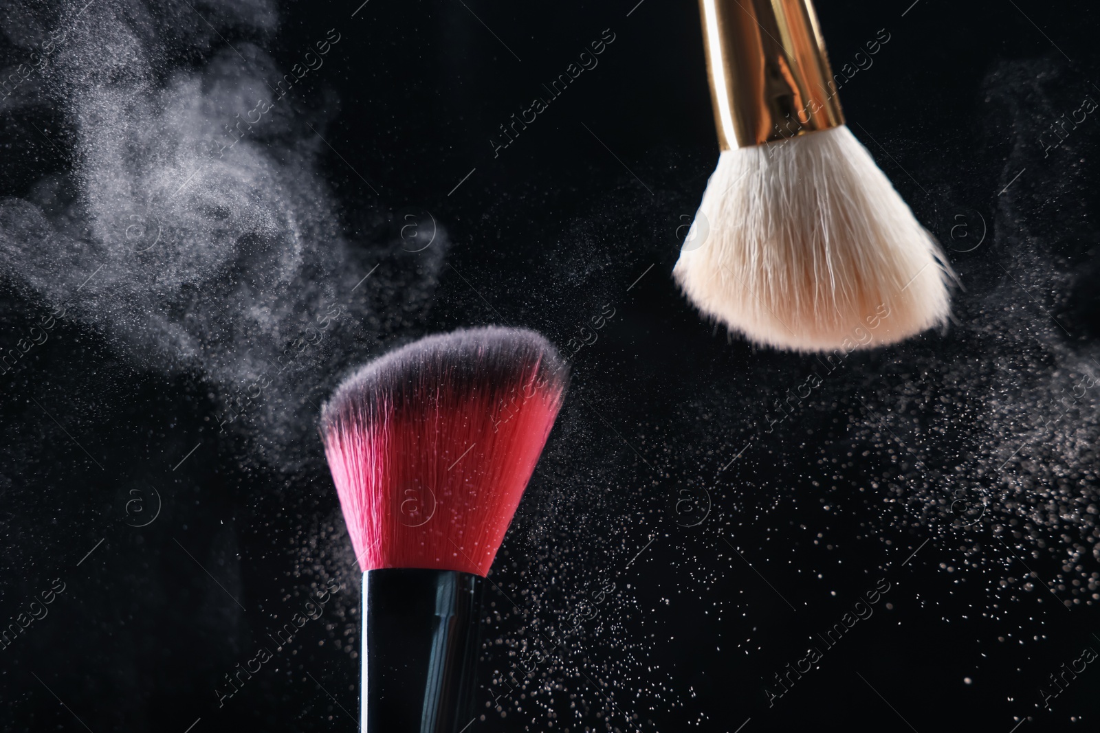 Makeup brushes with cosmetic powder on black background, closeup Photo of Makeup brushes with cosmetic powder on black background, closeup