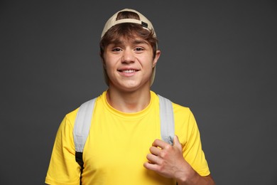 Photo of Portrait of smiling teenage boy in baseball hat on grey background