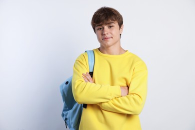 Photo of Cute teenage boy looking at wristwatch on light grey background