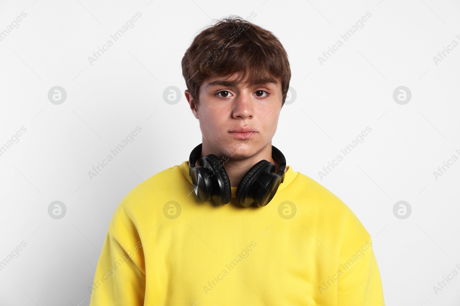 Photo of Portrait of teenage boy with headphones on light grey background