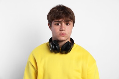 Photo of Portrait of teenage boy with headphones on light grey background