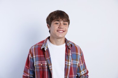 Photo of Portrait of smiling teenage boy on light grey background