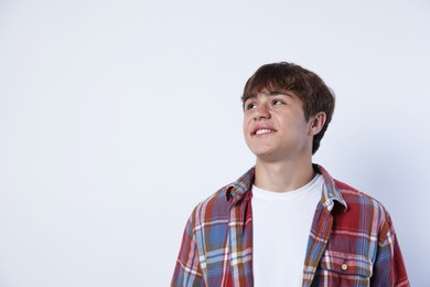 Photo of Smiling teenage boy on light grey background. Space for text